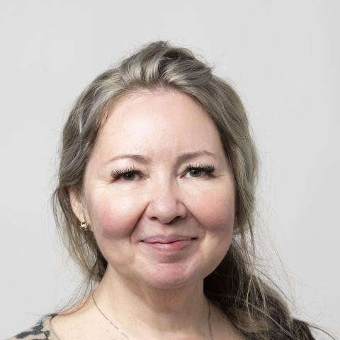 Woman wearing leopard print sweater smiling directly at camera
