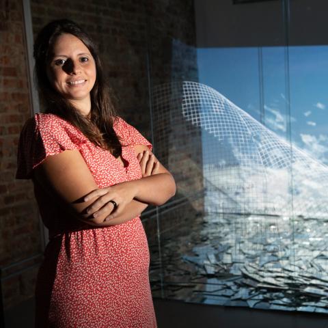 Women in a red dress standing next to an ocean like image