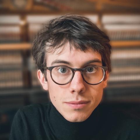 Man wearing glasses and turtle neck shirt looking at camera