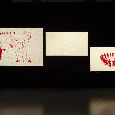 Three images are projected onto a wall. Each image features a red and white animation.