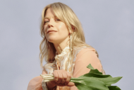 Portrait of Basia Bulat wearing a soft dress and holding flowers 