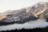 snowy mountain with mist in foreground