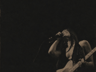 black blackground with overlay of a woman singing and playing guitar