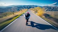 Man on a skate taking speed in a road 